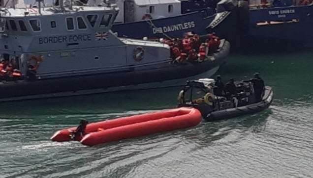 An empty dinghy is towed into Dover Marina following the arrival of a large group of people on the Border Force patrol boat behind. Pictures Sam Lennon KM Group