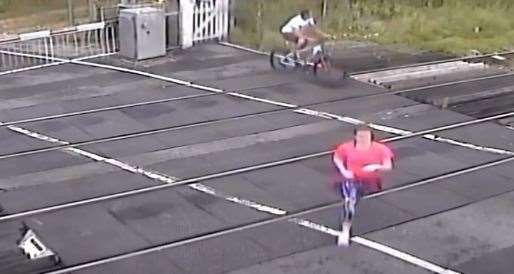 The jogger and cyclist making their way across the level crossing