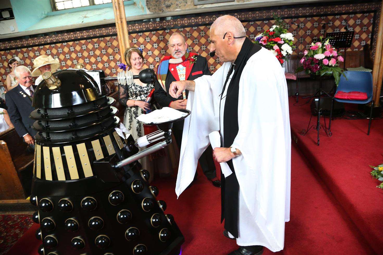 Fortunately the Dalek only interrupted the ceremony to provide the ring, handing it here to rector of St Peter & St Paul's Graham Herbert.