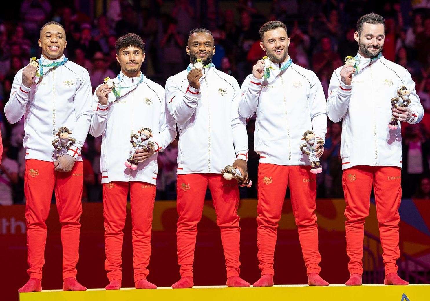 Courtney Tulloch, centre, Giarnni Regini-Moran, fourth from left, and James Hall, fifth from left, celebrate team gold at the Commonwealth Games earlier this year. Picture: Team England