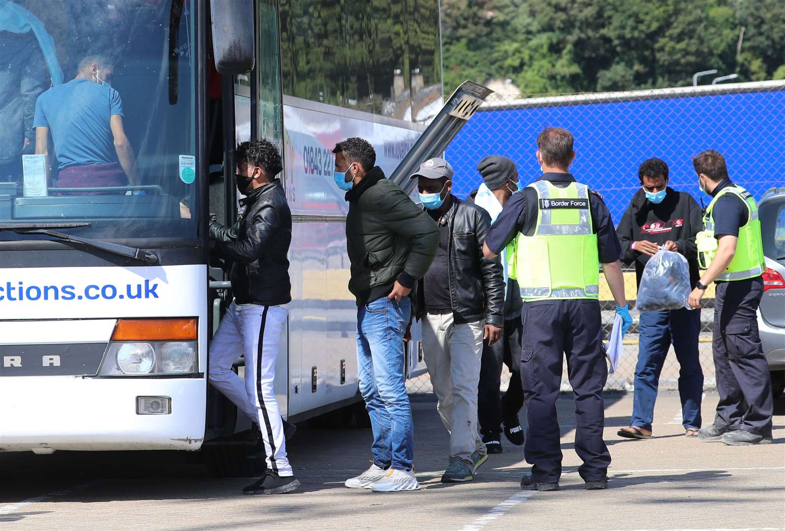 Border Force officers escort a group of men thought to be migrants onto a waiting bus after they were brought into Dover, Kent (Gareth Fuller/PA)