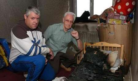 Father of the children Trevor Wood, left, with one of the rescuers Derek Cole in the fire-damaged bedroom. Picture: MATT WALKER