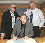 MAN OF THE MOMENT: Crofts puts pen to paper watched by Paul Scally and Stan Ternent. Picture: KEITH SLATER