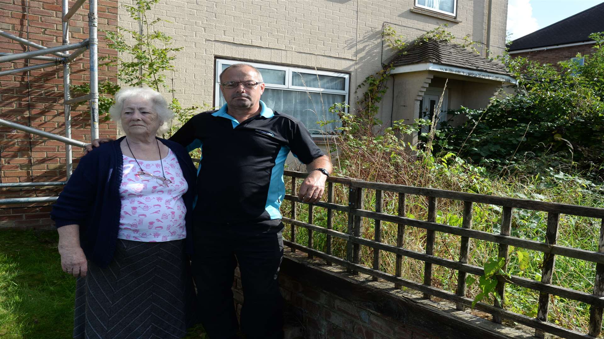 Maureen and Darren Dodd by the overgrown property next to their house in Highland Road