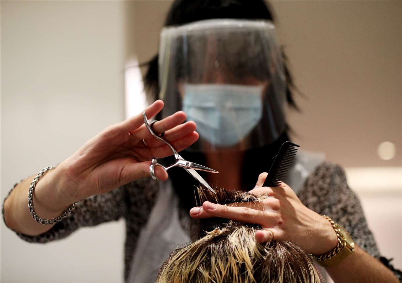 Stylist Tommy D’Amour cuts the hair of client Lea Jantz at Tusk Hair in Camden, North London. Hair salons are allowed to reopen but they cannot offer beauty treatments (Jonathan Brady/PA)