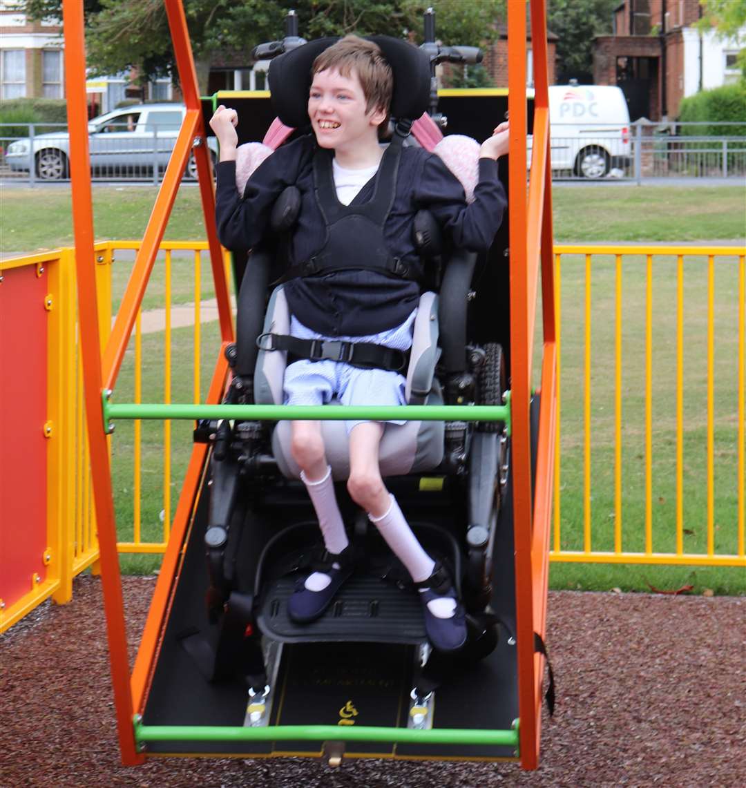 Amber from Beacon Park School tries out the new wheelchair swing in Radnor Park, Folkestone