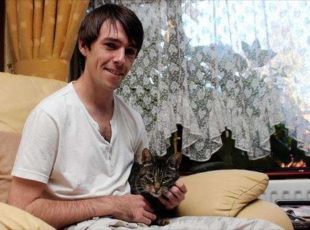 Tom Marchington and his cat Nesta. The cat escaped from a cattery three months ago - and turned up in their kitchen.