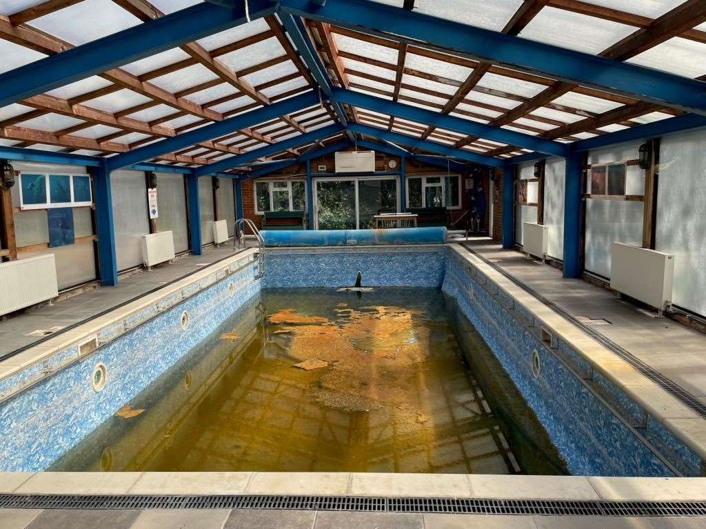The run-down swimming pool had dirty water inside it. Picture: Clive Emson