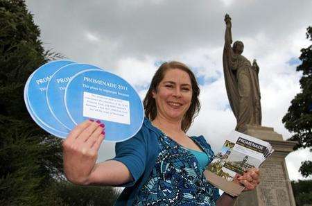 Allison Young, one of the organisers of Promenade, poses at the war memorial, Bridge Road, Sheerness, with blue plaques which residents can display throughout the festival