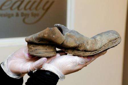 Sam Harris, collections officer at Maidstone Museum, with a boot found in a wall dating from around 1740