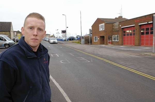 Firefighter Daniel Bowles in front of the reminder to road users that there is no stopping in front of the fire station on St Michael's Road, Sittingbourne