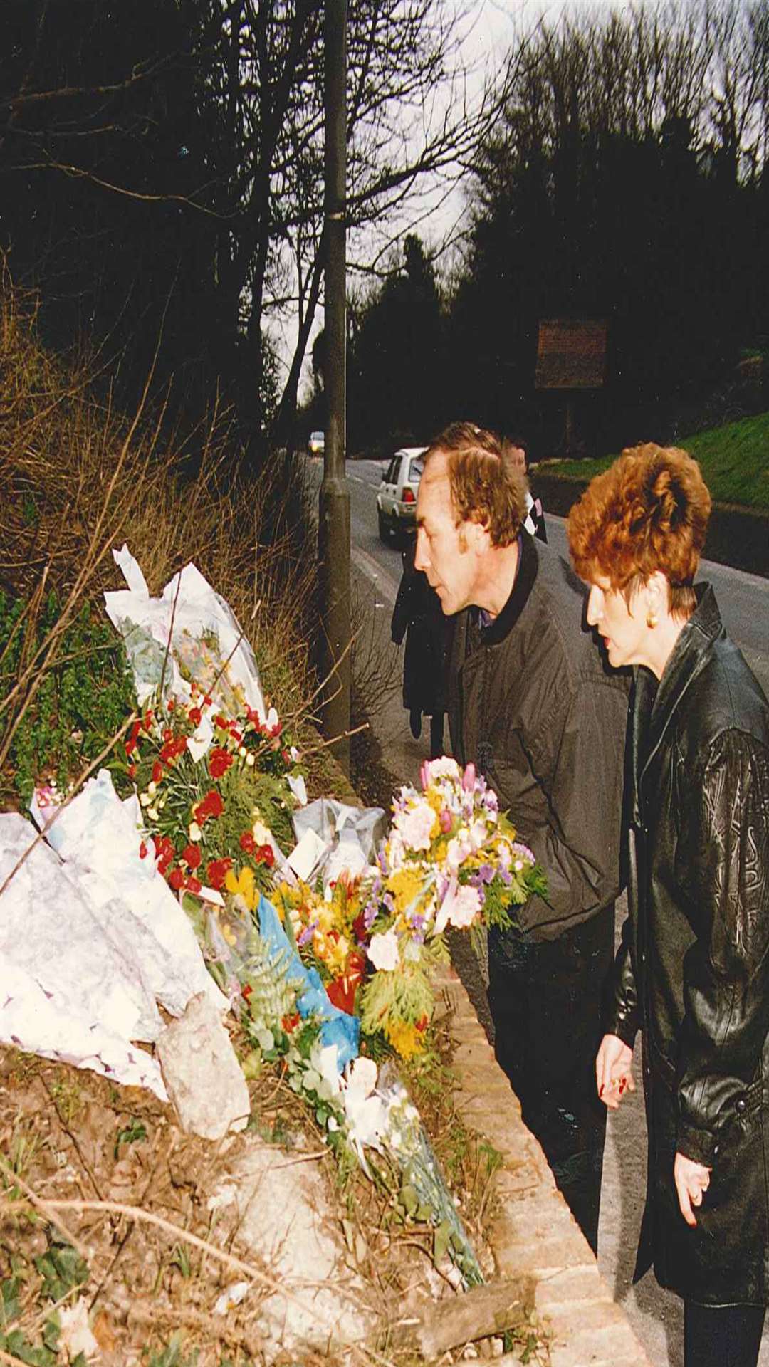 Cliff and Linda Tiltman inspect floral tributes left near the scene of their daughter's killing