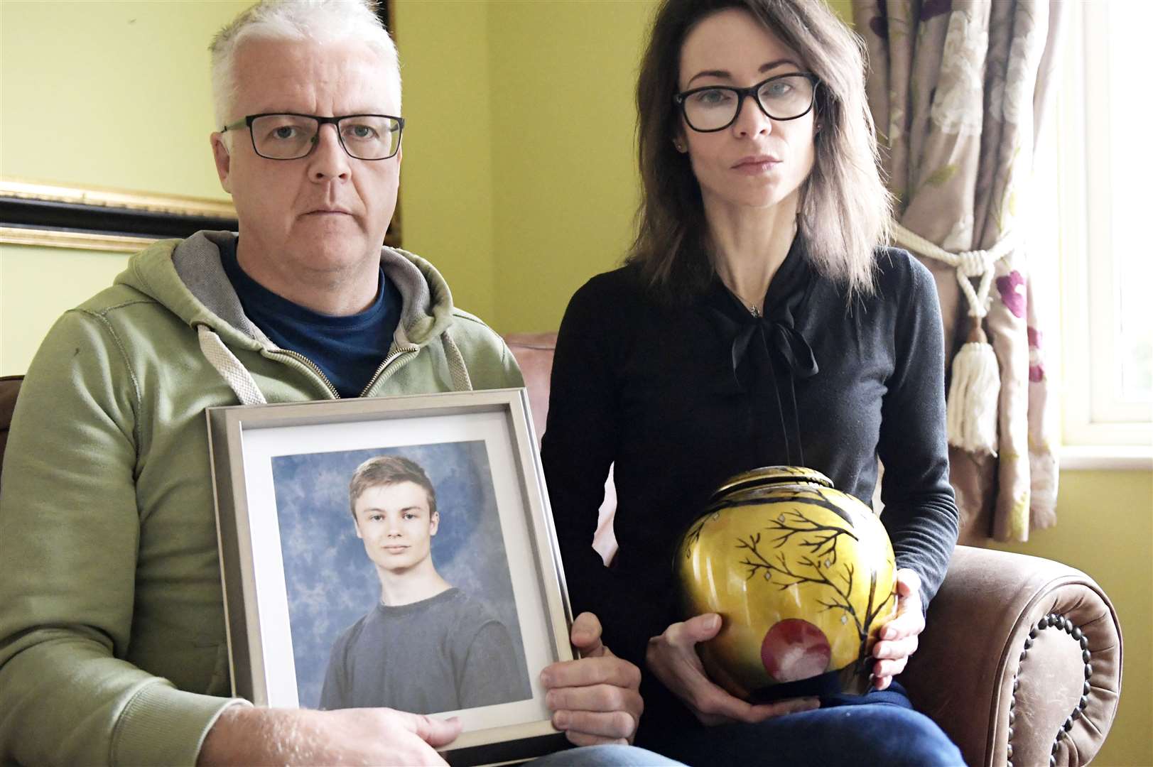 Parents Colin and Alison Webb with a photo of their 16-year-old son, Lucas, and an urn containing his ashes