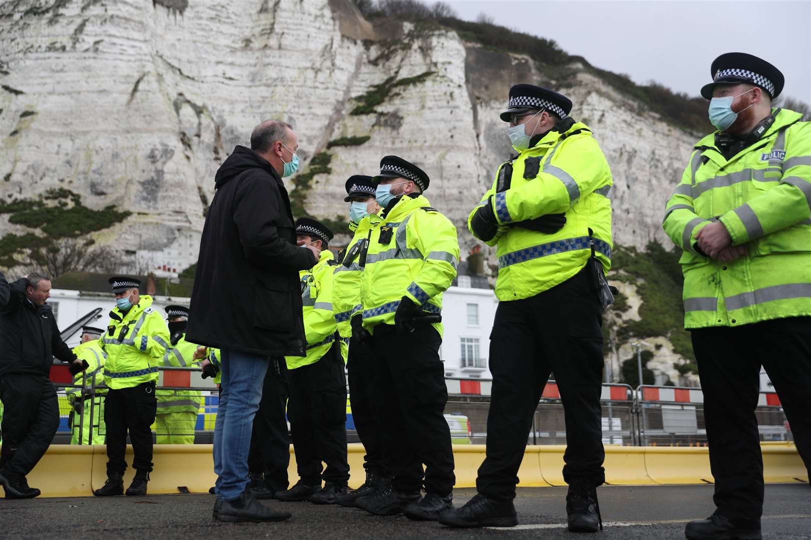 A haulier speaks to police officers blocking the entrance to the Port of Dover (Andrew Matthews/PA)