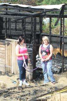 Ellesse Norris, 15, with her mother, Emma, in the ruins of their Aylesford stables after the fire