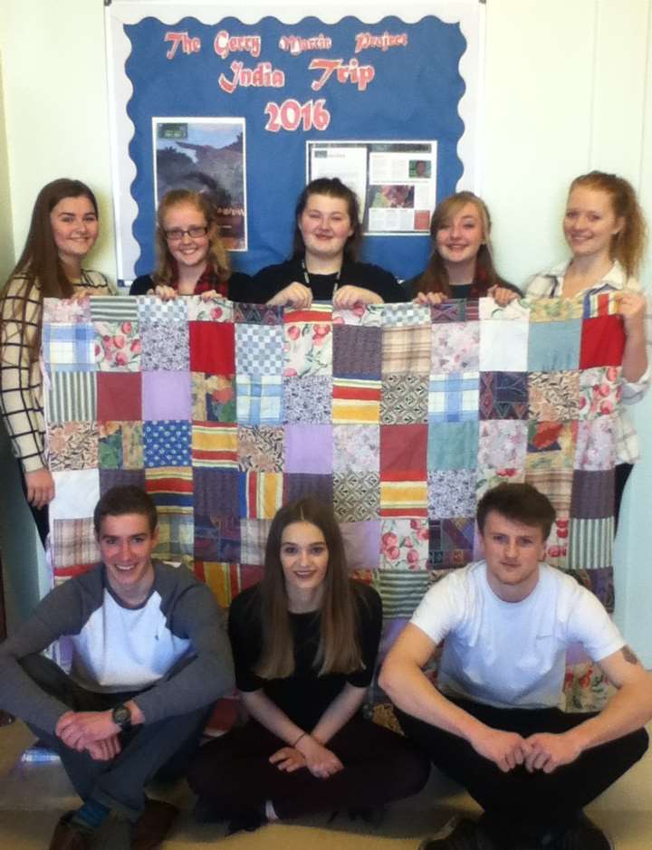 Pupils from Castle Community College with the patchwork quilt donated by Davina Brunt from the tea station at Milage