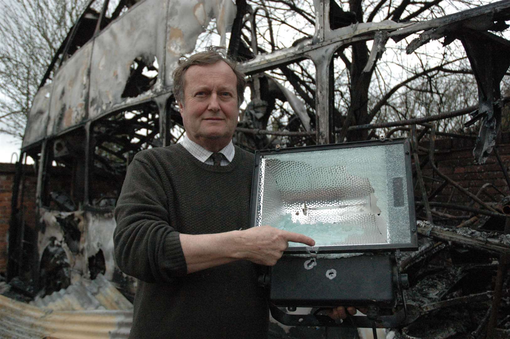 Morghew Park owner Tom Lewis holds a security light damaged in a previous vandalism shooting at the premises
