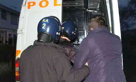 A suspect is placed in the back of a police van. Picture: BARRY GOODWIN
