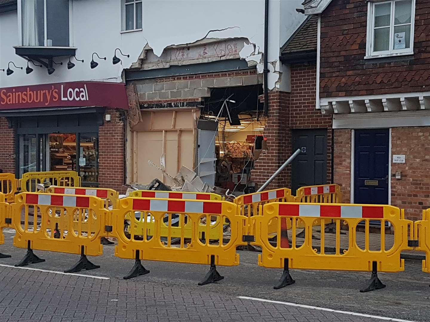 A section of wall has been completely removed revealing the inside of the shop