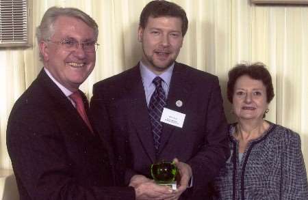 Michael Cooke of the Green Apple Awards presents the trophy to Simon Dolby and Gillian Reuby of the Kent Walking Bus Project