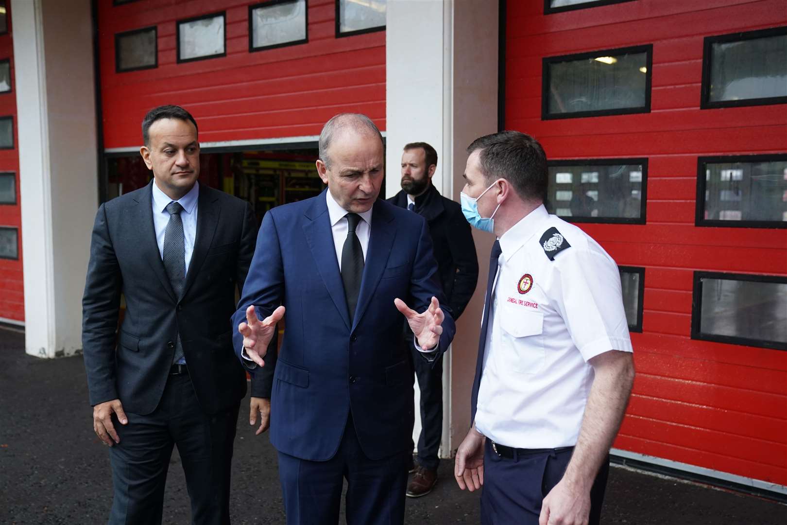 Tanaiste Leo Varadkar and Taoiseach Micheal Martin meeting firefighter Kevin Boylan at Letterkenny fire station on Sunday (PA)