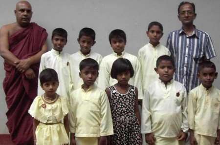 Kent tsunami relief co-founder Meththa Meththananda, right, with orphaned children and a priest during a recent visit to Sri Lanka. Picture courtesy KASTDA charity