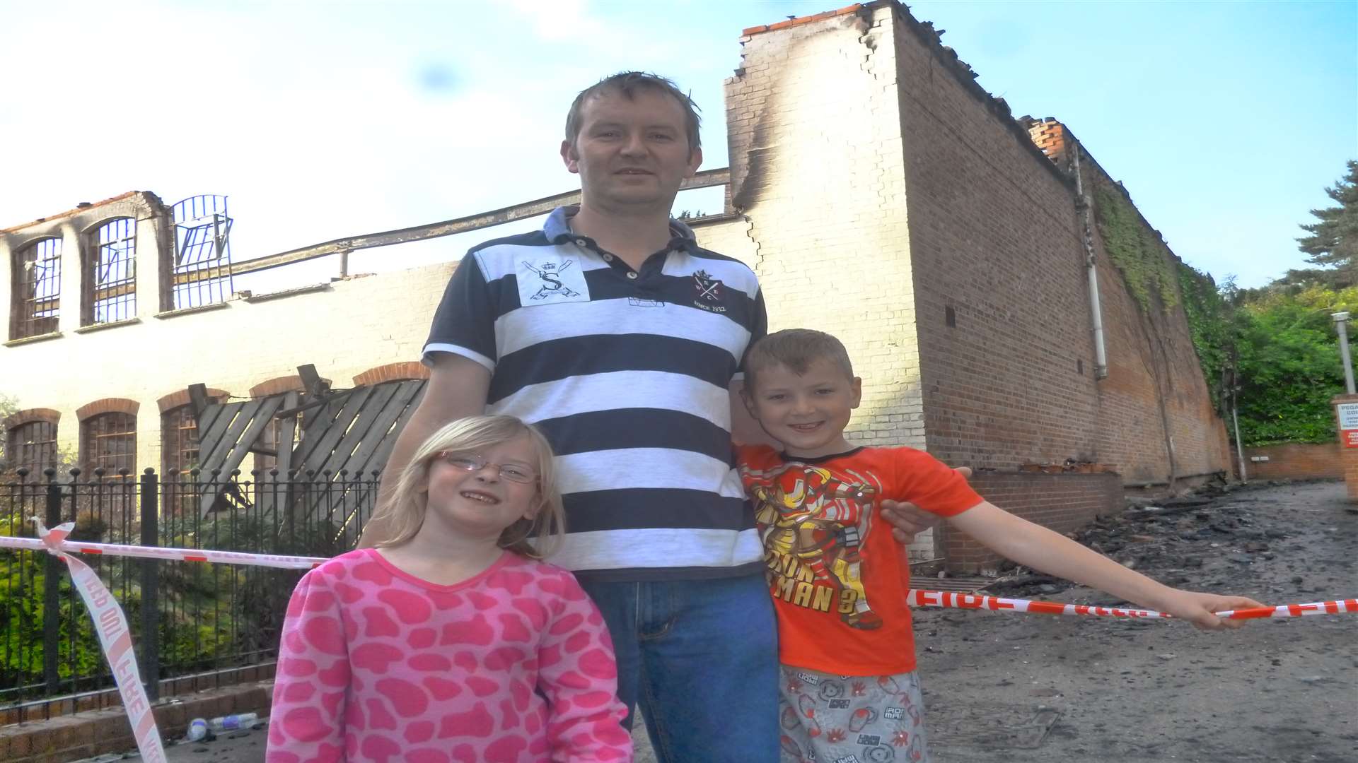 Olivia, Mark and Toby French outside the burnt out building