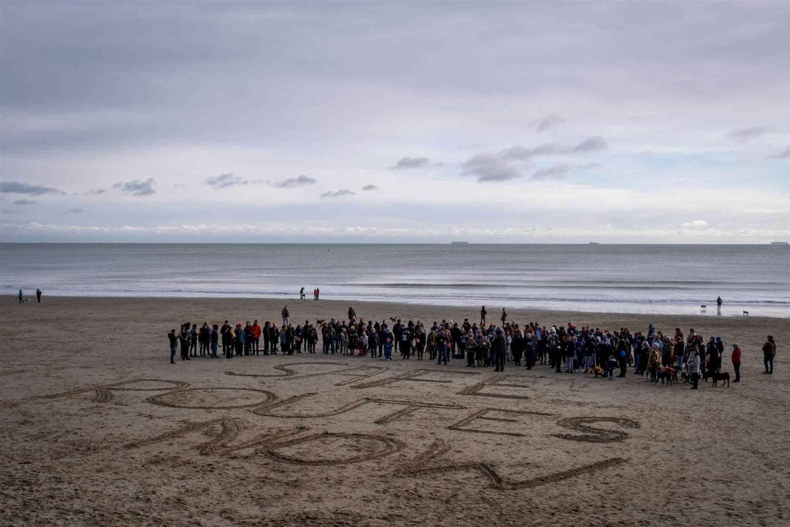 Folkestone residents peacefully stand behind ‘Safe Passage Now’ written in the sand on Sunny Sands Beach in November 2021. Picture: Andy Aitchison