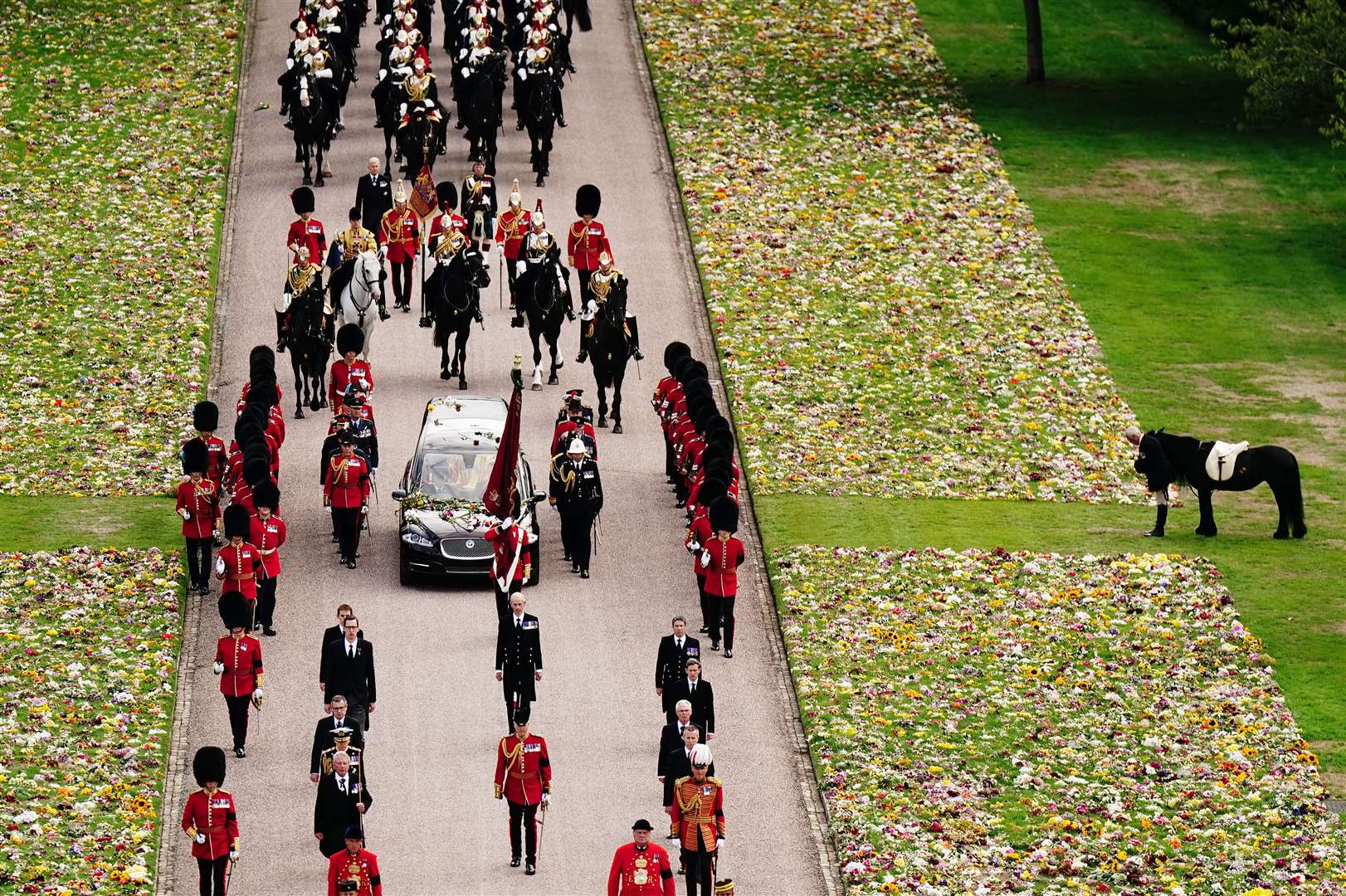 Emma, the monarch’s Fell pony, stands as the procession of the Queen’s coffin makes it way up the Long Walk (Aaron Chown/PA)