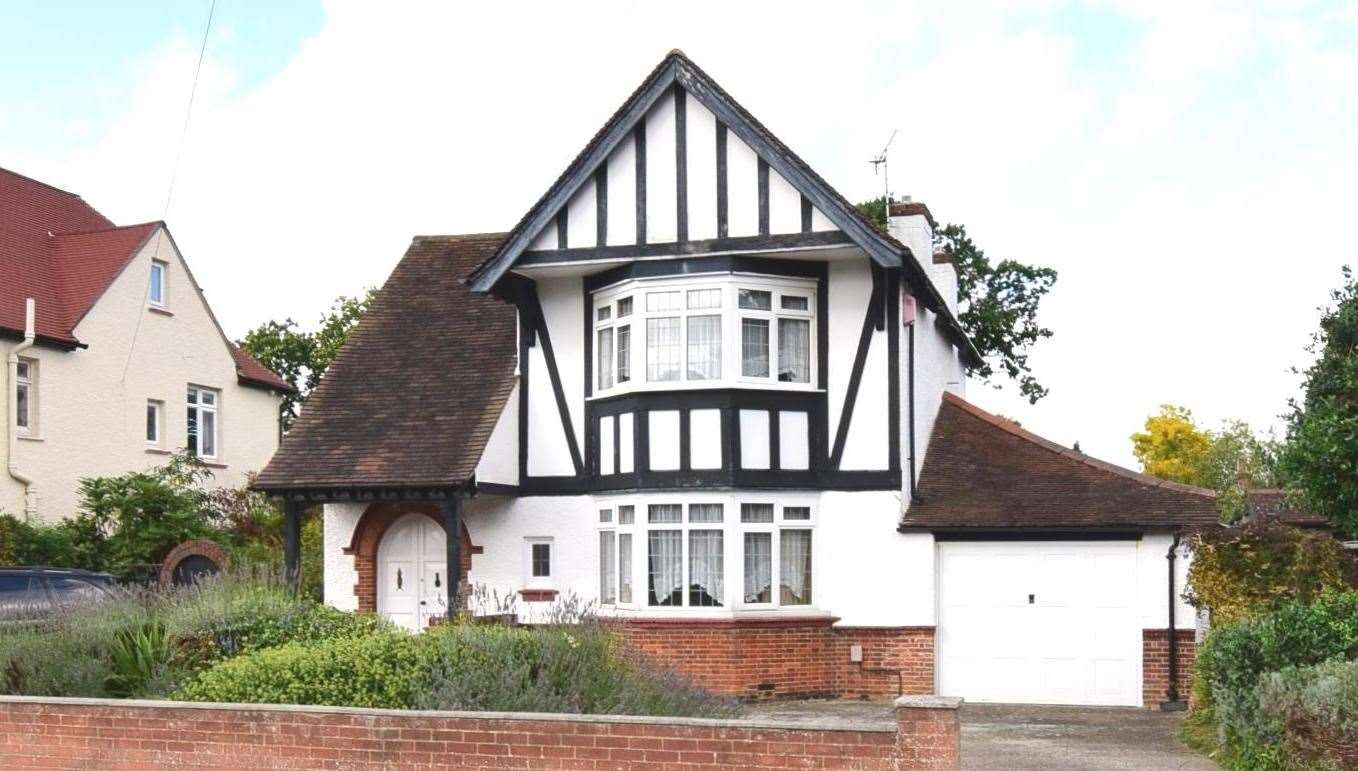 The 1930s house has bay windows and original curved front door