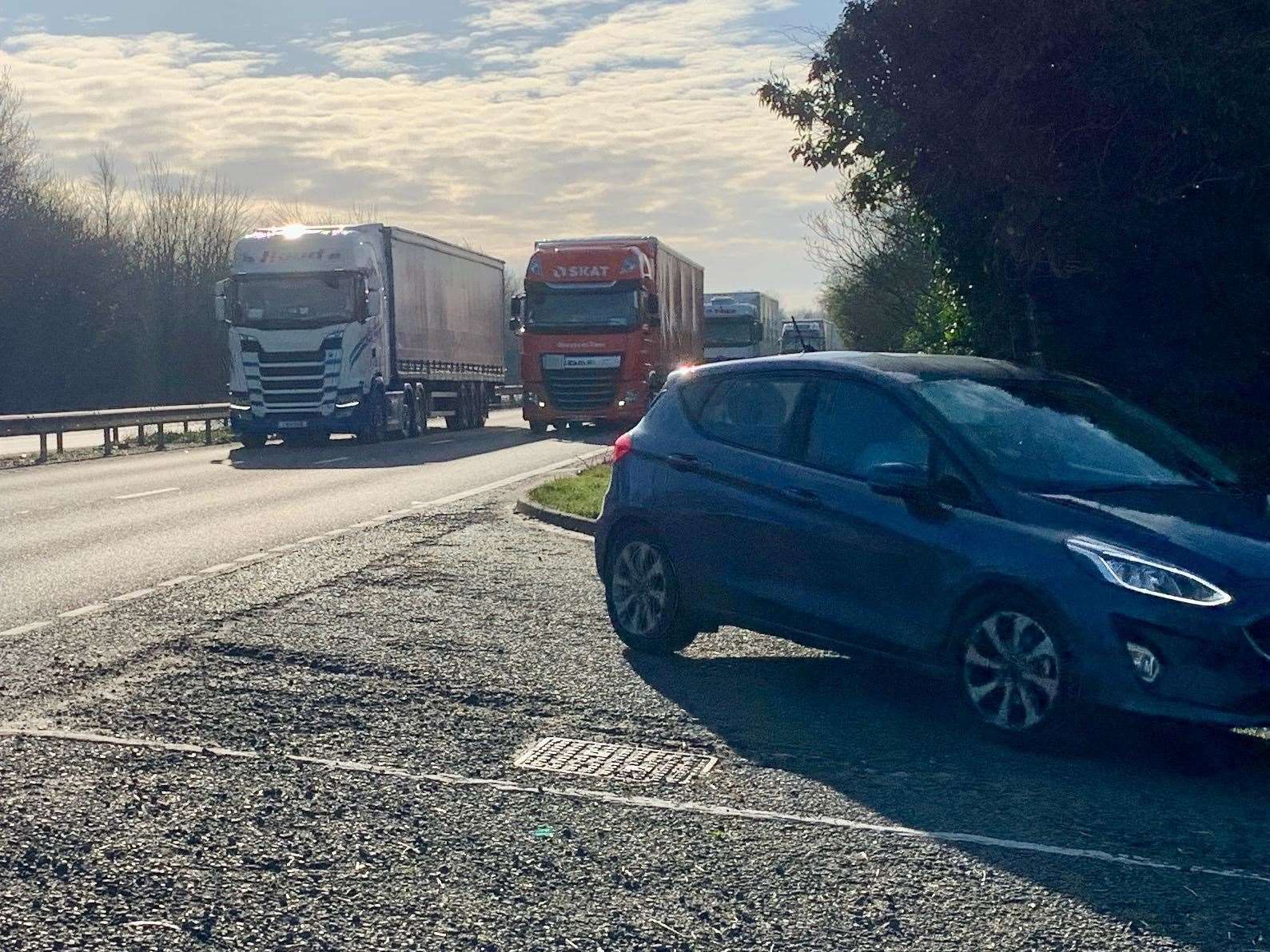A car pulls off the A2 and into Out Elmstead Lane as large lorries approach from behind. Picture: Mike Sole