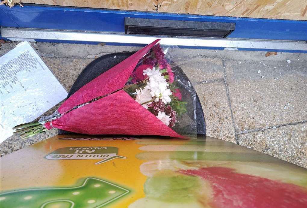 Flowers were placed behind a sign at the entrance to Thenu Convenience Store in Snargate Street, Dover, after the attack
