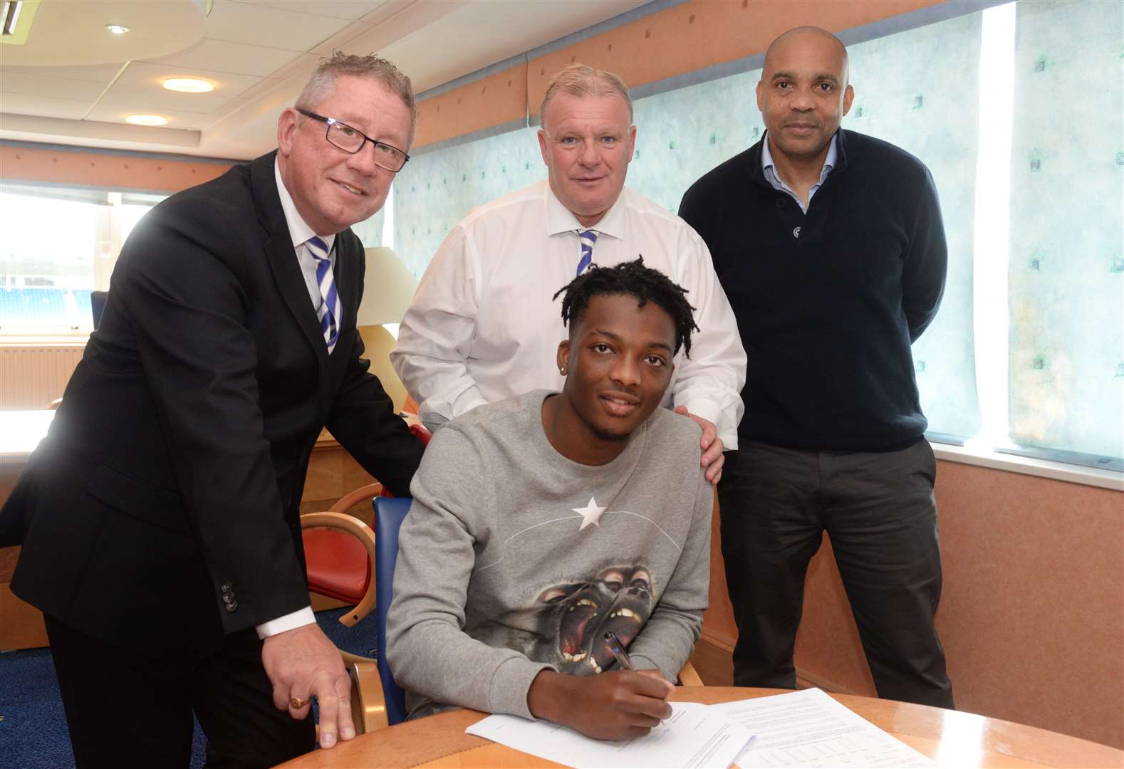 Gillingham chairman Paul Scally and manager Steve Evans with new signing Matty Willock and his father Charles. Picture: Chris Davey.