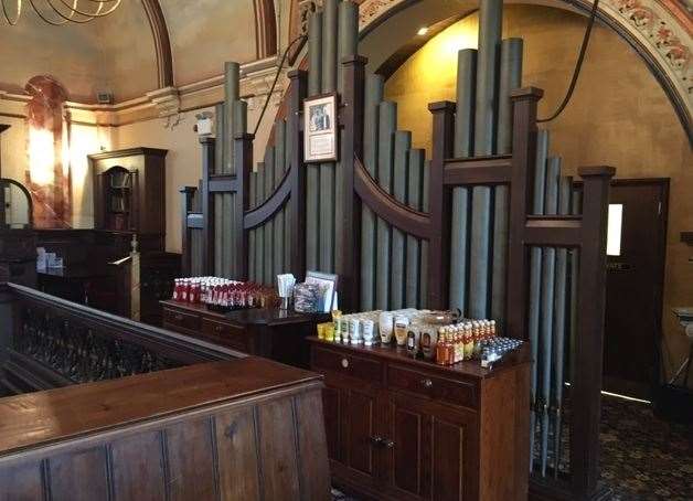 The rows of sauce bottles and stacked cutlery look incongruous in front of the organ pipes