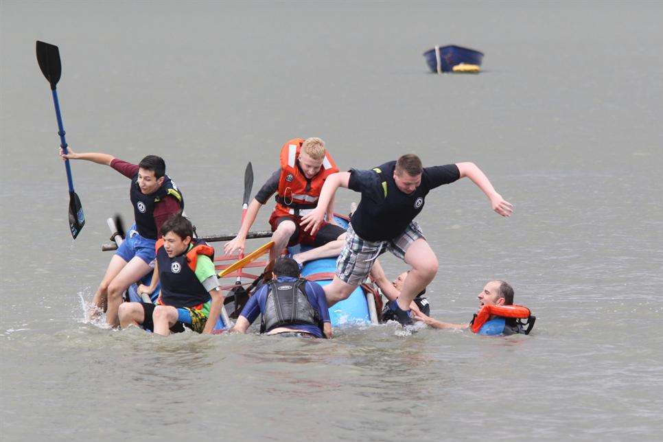 "Abandon Ship! " Must have been the cry. A team jump off their raft rather than being pulled off by fellow competitors in the water at The Raft Race at the Summer Fair at Greenhithe river front.