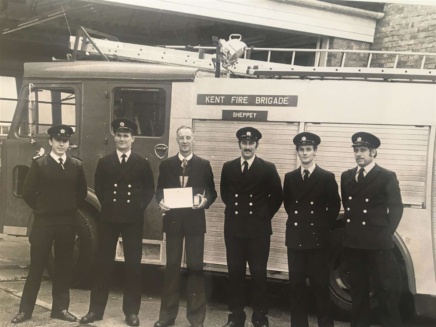 Sheppey firefighter Robert Hodgson with his commendation for helping the Fire Services National Benevolent Fund in 1990 with colleagues at Sheerness fire station