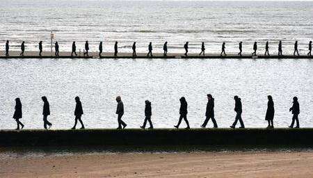 Walkers during their seven circuits of the bathing pool on Margate Main Sands for Hamish Fulton's exhibition at the Turner Contemporary