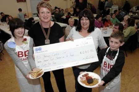 Mary Daly presents the cheque for £12,810 to Chritine Lux of the Canterbury MS centre watched by Victoria Mellowship and Adam Jones at the Big Breakfast held in Adisham village hall