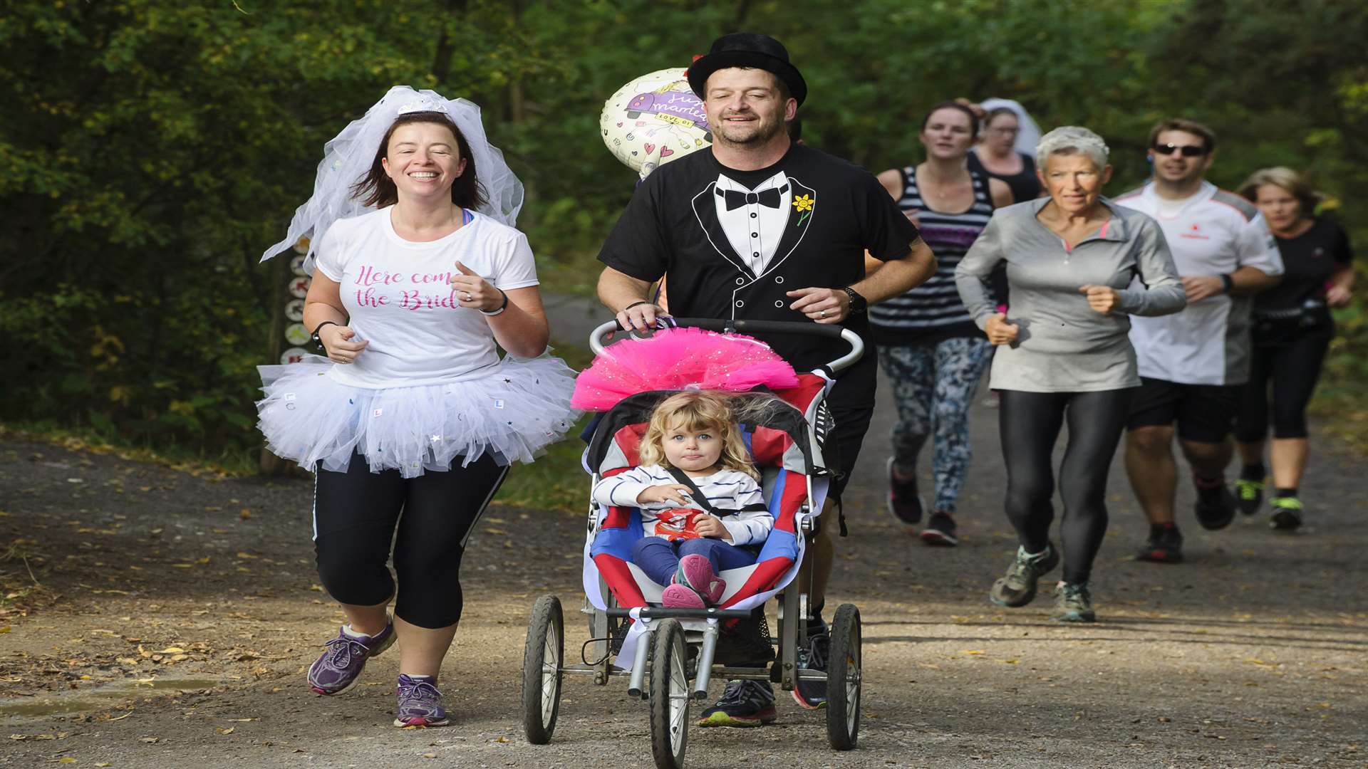 Becky and Matt run the course, with daughter Emily, 2, in the buggy. Picture: Andy Payton