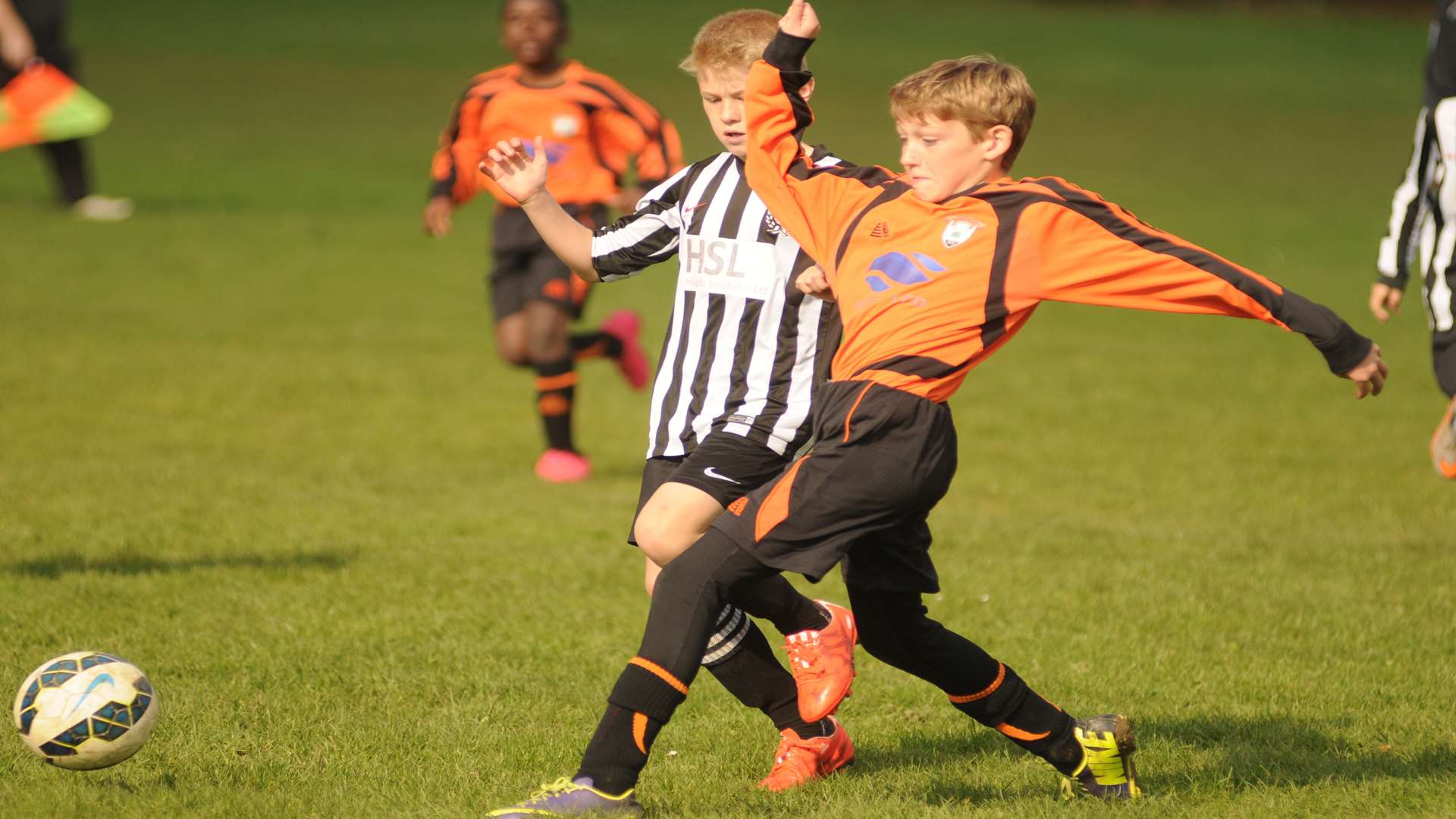 Lordswood Youth Tigers (orange) and Real 60 go for the same ball in Under-13 Division 1 Picture: Steve Crispe