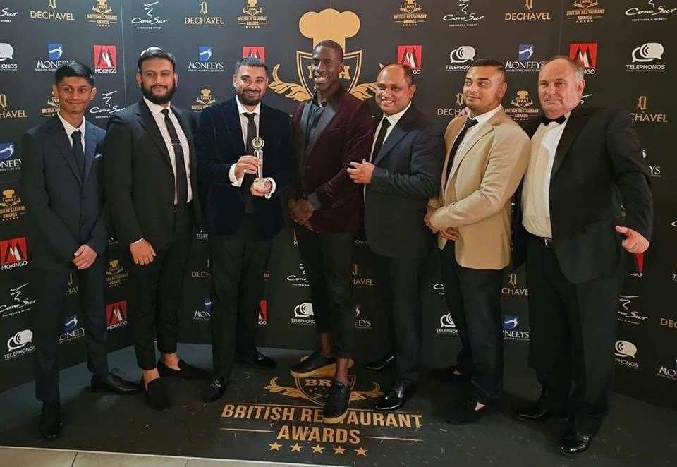 Tariq Ahmed (third right) and his brother Jamil Trofder (third left) along with Olympic legend Dwain Chambers (centre) at the awards ceremony in London