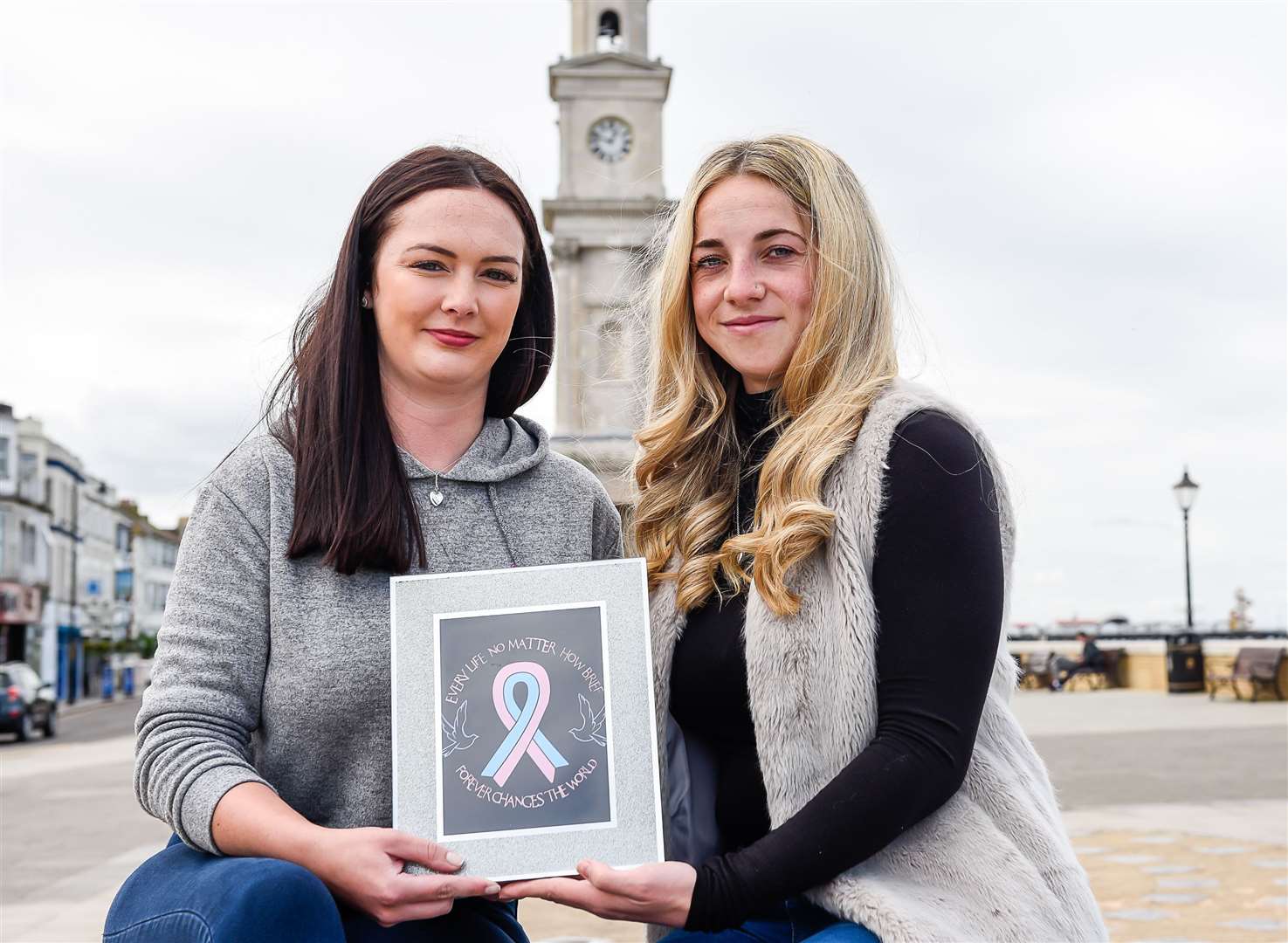 Laura Carver and Carys Groombridge in front of the clock tower in Herne Bay, which will light up pink and blue to mark Baby Loss Awareness Week