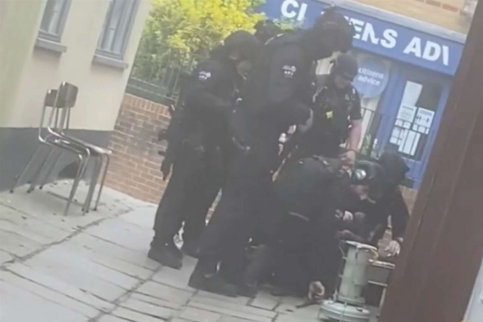 Armed police were seen pinning a man to the ground