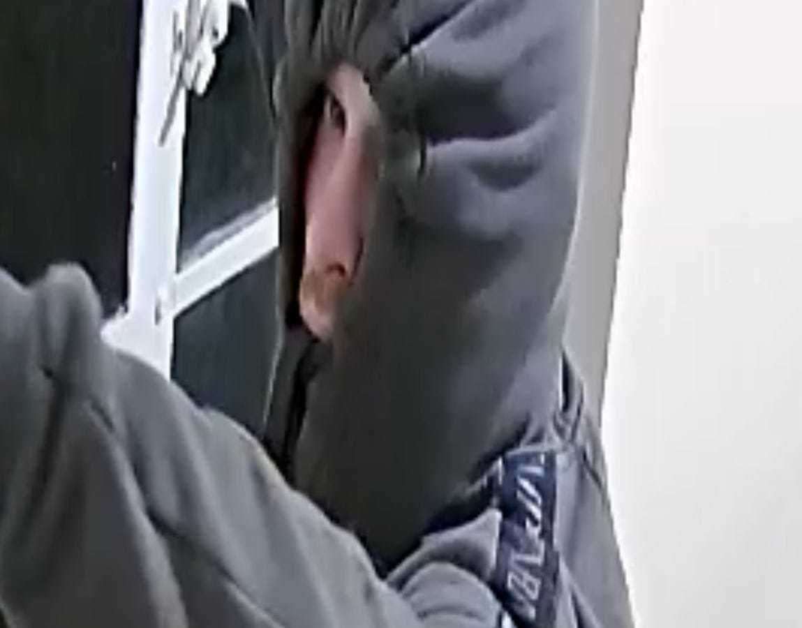 The burglar keeps his face mostly hidden with a hoodie