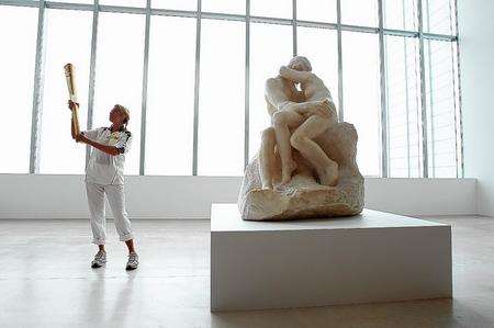 Artist Tracy Emin holds the Olympic Flame, inside the Turner Contemporary Gallery alongside Rodin's The Kiss