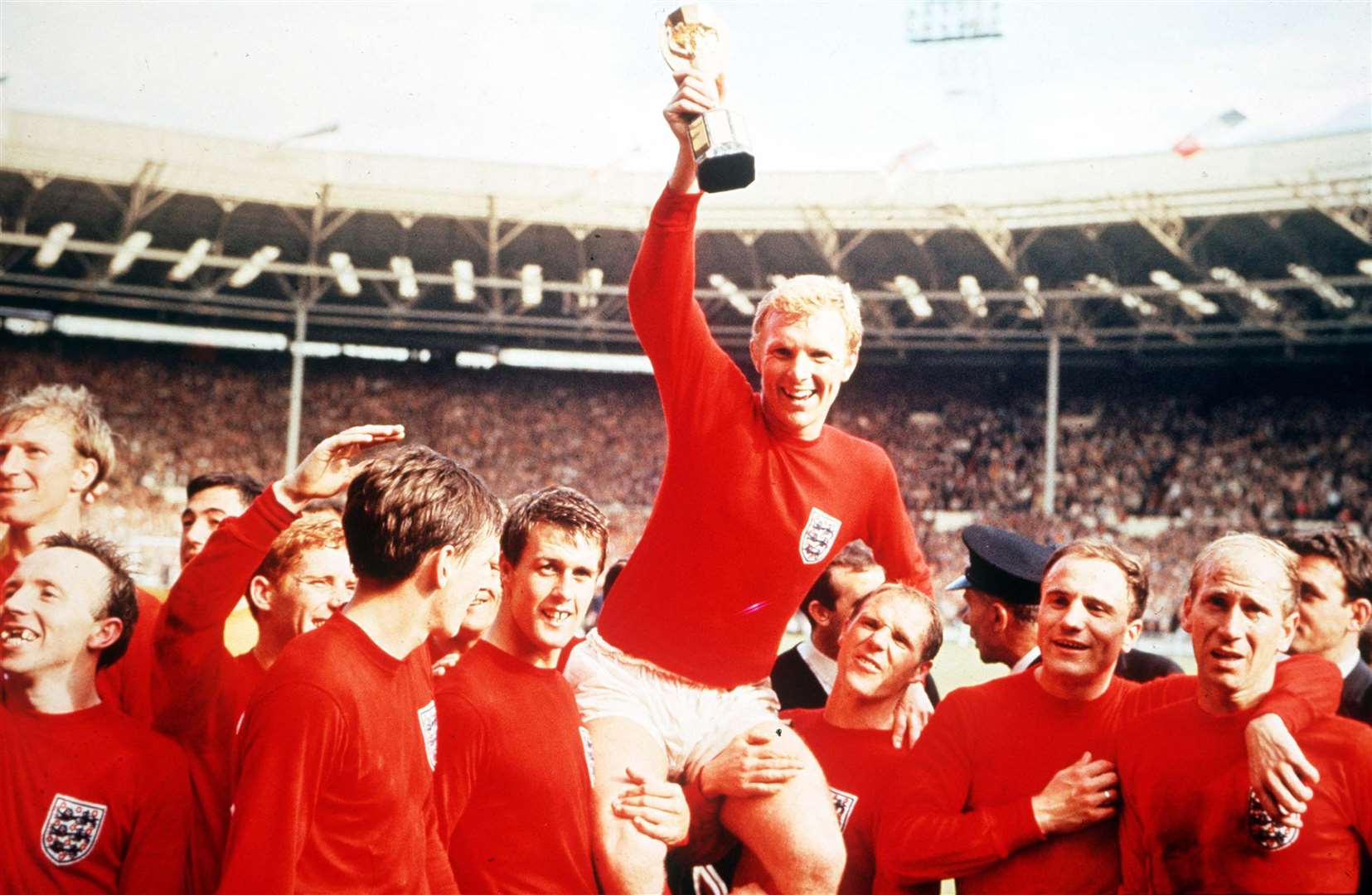 England's captain Bobby Moore holds aloft the Jules Rimet World Cup trophy as he sits on the shoulders of his teammates, from left, Jack Charlton, Nobby Stiles, Gordon Banks (behind), Alan Ball, Martin Peters, Geoff Hurst, Bobby Moore, Ray Wilson, George Cohen and Bobby Charlton. Picture: Popperfoto/Getty Images