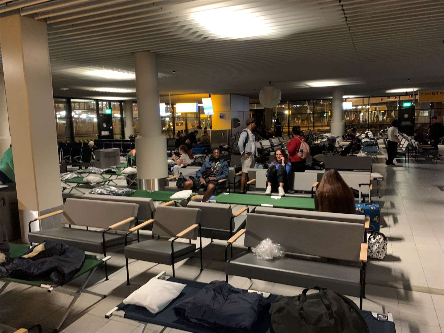 Passengers sleeping at Amsterdam Airport overnight on seats and folding beds (Matthew Creed/PA)