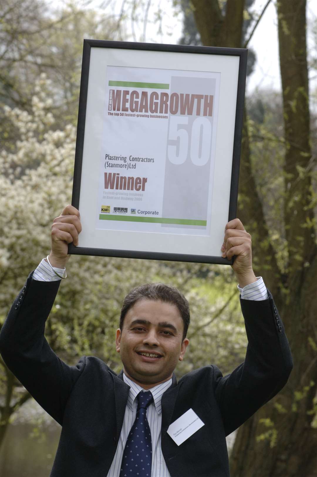 Raj Manak holds aloft the winner certificate for Plastering Contractors (Stanmore) in 2006