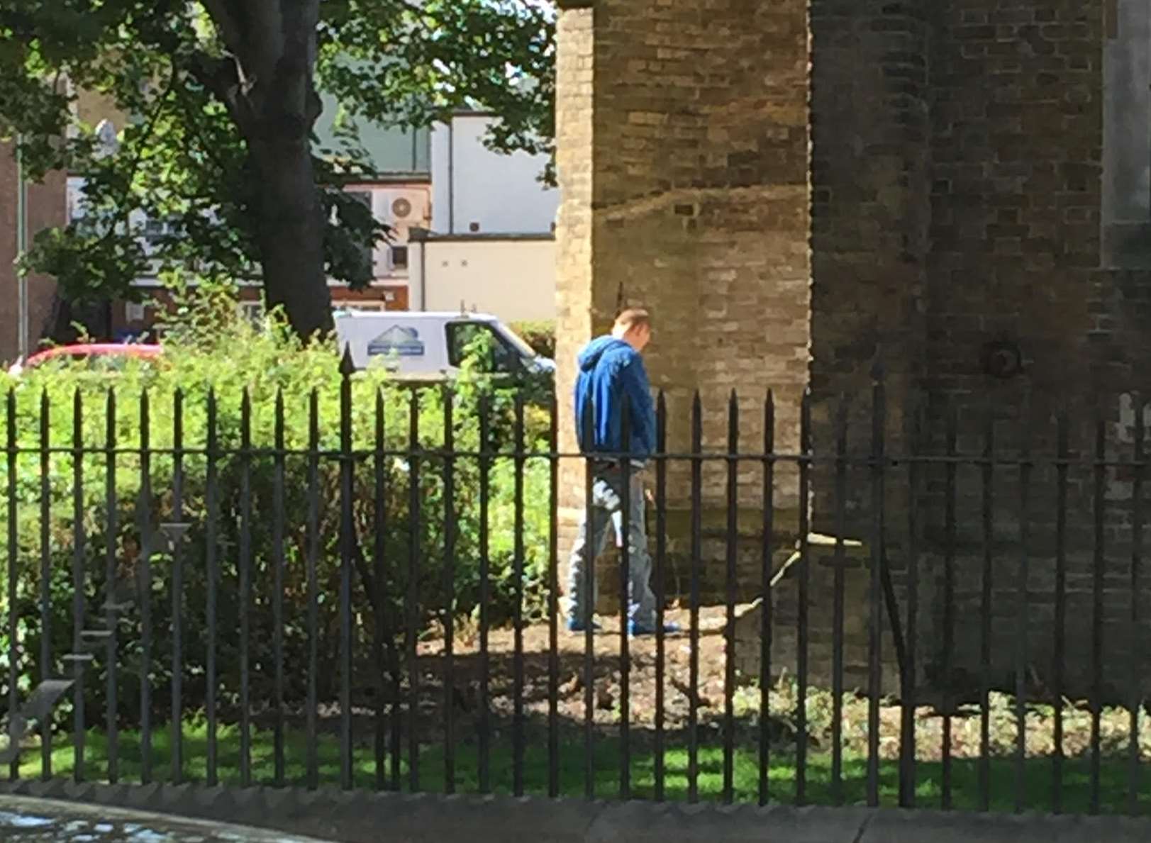The man is snapped relieving himself against the historic building