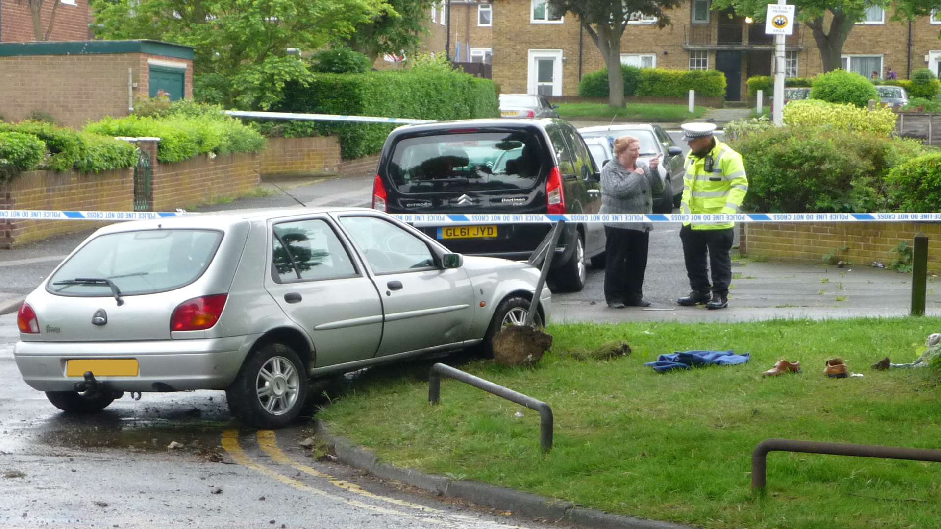 Police officers talk to a witness in Twydall where a pensioner who died crashed his car